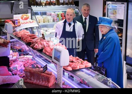 La reine Elizabeth II s'entretient avec des co-propriétaires d'HM Bouchers Sheridan M. Barry Florence (à gauche) et M. John Sinclair (à droite), lors d'une visite à Ballater Aberdeenshire à entendre parler de la reprise en cours d'efforts à la suite de graves inondations en décembre dernier. Banque D'Images