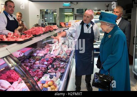 La reine Elizabeth II s'entretient avec des co-propriétaires d'HM Bouchers Sheridan M. Barry Florence (centre) et M. John Sinclair (à droite), lors d'une visite à Ballater Aberdeenshire à entendre parler de la reprise en cours d'efforts à la suite de graves inondations en décembre dernier. Banque D'Images