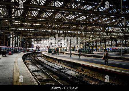 Une femme attend des passagers sur une plate-forme à la gare centrale de Glasgow - le principal terminus ferroviaire principale à Glasgow, Ecosse Banque D'Images