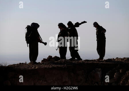 Un groupe de femmes des combattants kurdes des unités pour femmes libres raccourcie en YJA STAR l'aile militaire des femmes du Parti des Travailleurs du Kurdistan PKK lourdement armés stand dans une zone montagneuse dans la campagne de Makhmur près de Mossoul dans le Nord de l'Irak Banque D'Images