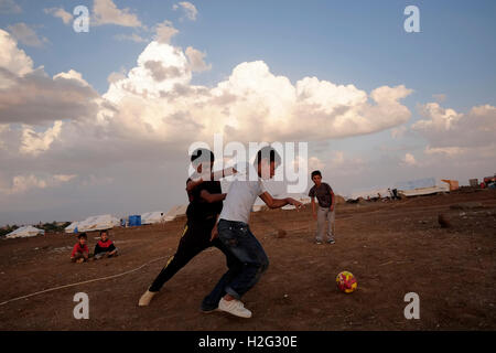 Enfants jouant au football dans yazidis Nawroz camp de réfugiés qui a été créé pour mettre à l'abri des Syriens déplacés de la guerre civile en Syrie puis occupées par des personnes déplacées de la minorité secte Yazidis, fuyant les violences dans la ville irakienne de Sinjar situé à côté de la ville d'al-Malikyah Rojava dans la région kurde autonome, au Nord Est de la Syrie. Banque D'Images