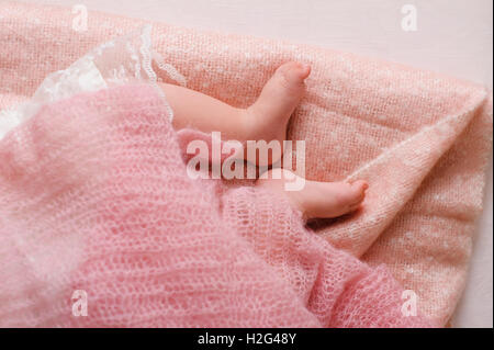 Pieds de bébé nouveau-né. Sleeping Baby Foots sur feuille rose du lit Banque D'Images