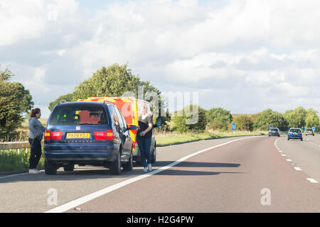 Deux jeunes femmes et voiture ventilées sur la A1(M) la plus proche avec l'AA van Banque D'Images