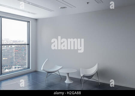 Belle salle d'attente avec mur blanc deux chaises et une table. Banque D'Images