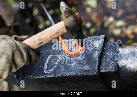 Forgeron forge fer à repasser, boucle de marteau sur enclume dans une forge rurale Banque D'Images