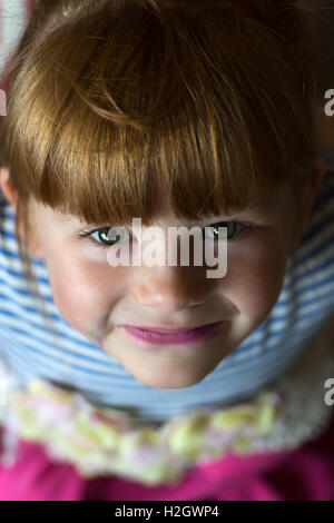 Jeune fille rousse à la recherche jusqu'à l'appareil photo montrant outre de son maquillage Banque D'Images