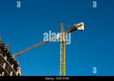 Crane at construction site contre le ciel bleu Banque D'Images