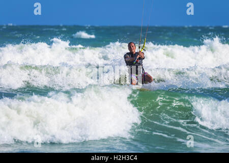 Athletic man riding sur kite surf board en mer vagues Banque D'Images