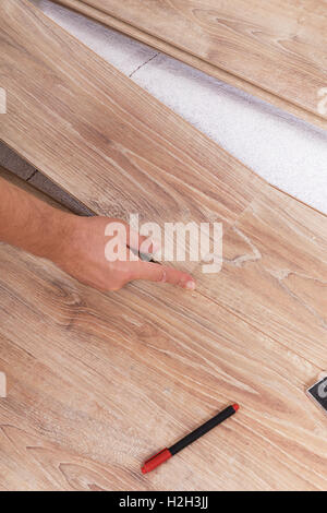 L'installation de parquet stratifié. Doublure de plancher Carpenter conseils scolaires à chaque autre montage d'une planche Banque D'Images