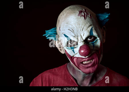 Portrait d'un clown maléfique effrayant sur un fond sombre Banque D'Images