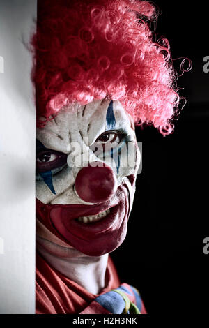 Portrait d'un clown maléfique effrayant sur un fond sombre Banque D'Images