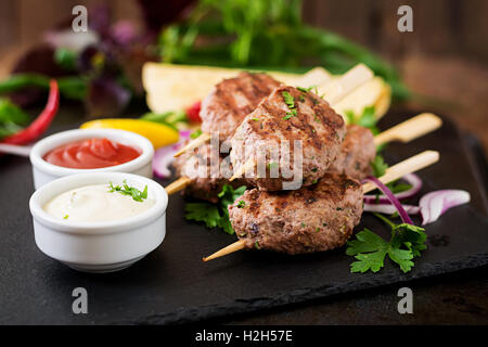 Kofta délicieux kebab (boulettes) avec la sauce et les tacos tortillas sur fond noir Banque D'Images