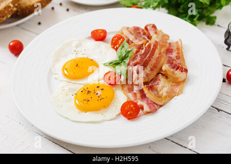 Petit-déjeuner anglais - œuf frit, tomates et bacon. Banque D'Images