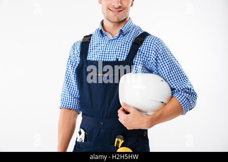 Portrait of a smiling worker holding helmet isolé sur fond blanc Banque D'Images