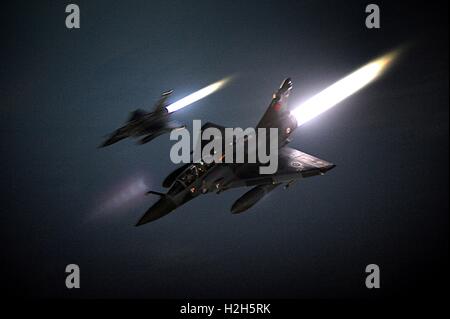 Deux armée de l'air Dassault Mirage 2000N de bombardiers tactiques des avions volent en formation nuit avec plein de post-combustion allumée. Banque D'Images