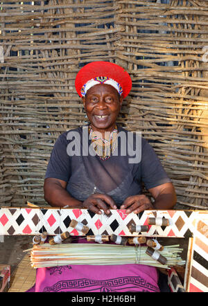 Shakaland Zulu femme dans le chapeau Zulu traditionnel montre son habileté à tisser pour les touristes au village culturel de Shakaland, Afrique du Sud Banque D'Images