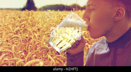 Close up of young man drinking beer mug en verre Banque D'Images