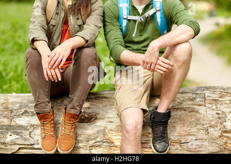 Close up of couple resting on tree trunk en plein air Banque D'Images