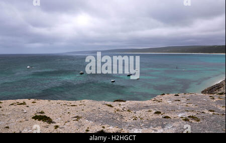 Ciel nuageux sur les eaux turquoises de l'océan Grand Sud avec des bateaux à Hamelin Bay, dans l'ouest de l'Australie avec bord falaise de calcaire. Banque D'Images