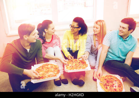 Cinq adolescents souriants de manger une pizza à la maison Banque D'Images