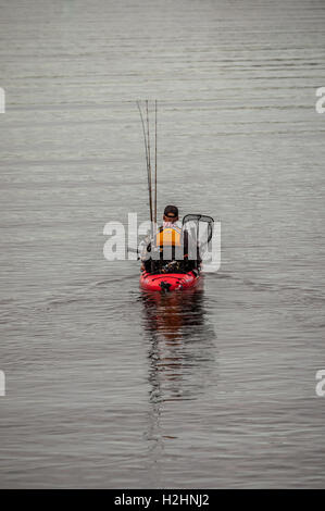 Cet homme tête pour une journée de pêche dans son pédalo. Il n'a ce genre de voile parce qu'il n'y a pas de place pour une pagaie en elle. Banque D'Images