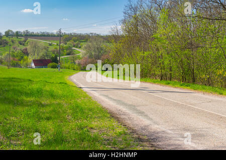 Paysage avec chemin sinueux vide par petit village Petro-Svistunovo au centre de l'Ukraine Banque D'Images