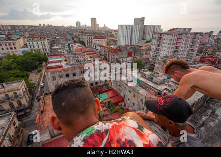 Trois personnes à par-dessus le bord d'un bâtiment dans le centre de La Havane, Cuba. Banque D'Images