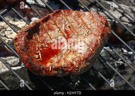 L'un de rares cuit boeuf grillé Steak barbecue avec des épices et des jus de viande préparés sur le barbecue, Close up Banque D'Images