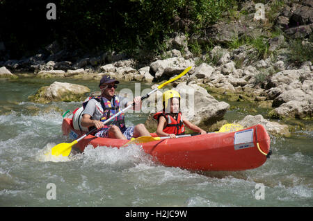 Le tourisme, les sports d'eau. Un père et son jeune fils en canoë sur les eaux à débit rapide de la Drôme. Près de Saillans, la Drôme, France. Banque D'Images