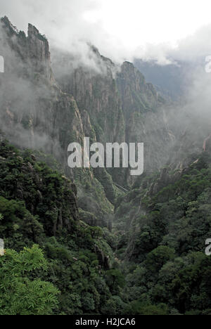 Les rayons de soleil dissiper le brouillard qui s'est installé dans le Canyon dans l'earl International Business Hotel - Huangshan Montagnes. Banque D'Images