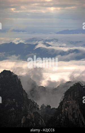 Soleil du matin illumine la mer de nuages flottant au-dessus de la montagne Huangshan. Banque D'Images