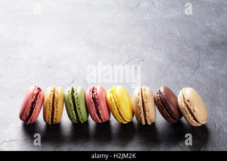 Macarons colorés sur la table en pierre. Macarons sucrés. Voir avec l'exemplaire de l'espace pour votre texte Banque D'Images