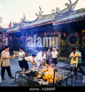 Les gens de l'argent fantôme brûlant en face de Thian Hock Keng Temple chinois, Singapour Banque D'Images