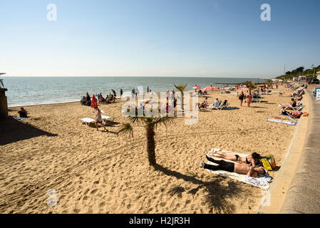 Groupe de personnes appréciant le soleil de l'été à la plage près de la jetée de Clacton dans l'Essex en Angleterre pendant l'été de 2016 Banque D'Images