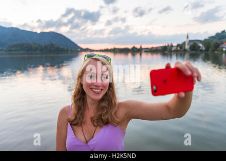 Jeune femme en souriant et selfies, Schliersee, Haute-Bavière, Bavière, Allemagne Banque D'Images