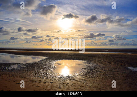 Soleil dans le ciel au-dessus de sable à marée basse out Banque D'Images