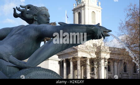 Fontaine à Trafalgar Square avec St Martin-in-the-champs dans l'arrière-plan un jour de printemps. Banque D'Images