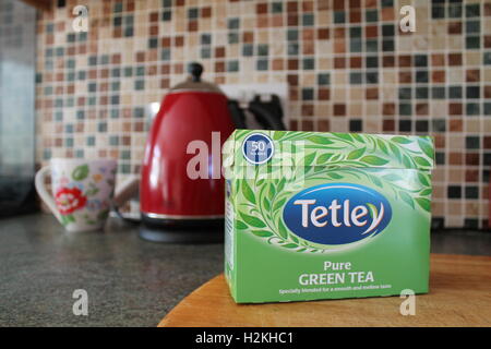 Fort de Tetley pure thé vert en face d'un rouge électrique et floral mug dans une cuisine Banque D'Images