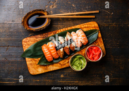 Nigiri Sushi Situé sur bambou vert feuille de bois d'olive avec la sauce soja sur fond de bois Banque D'Images