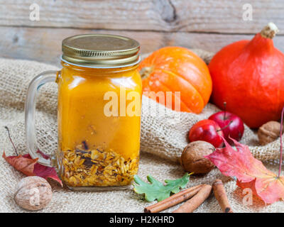 Petit déjeuner sain. Un Smoothie fait de la citrouille et des pommes avec granola et noix dans un pot Mason. Un style rustique. Selective focus Banque D'Images