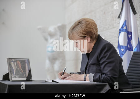 Berlin, Allemagne. Sep 30, 2016. La chancelière allemande, Angela Merkel, écrit une entrée dans le livre de condoléances pour le défunt ancien président israélien Shimon Peres (1923-2016) dans l'ambassade d'Israël à Berlin, Allemagne, 30 septembre 2016. Photo : MICHAEL KAPPELER/dpa/Alamy Live News Banque D'Images