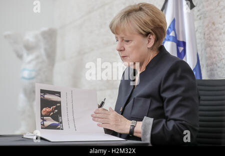 Berlin, Allemagne. Sep 30, 2016. La chancelière allemande, Angela Merkel, écrit une entrée dans le livre de condoléances pour le défunt ancien président israélien Shimon Peres (1923-2016) dans l'ambassade d'Israël à Berlin, Allemagne, 30 septembre 2016. Photo : MICHAEL KAPPELER/dpa/Alamy Live News Banque D'Images