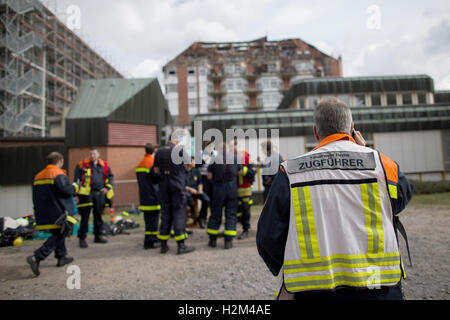 Bochum, Allemagne. Sep 30, 2016. Les pompiers se tenir en face de l'immeuble à l'hôpital après une Bergmannsheil feu durant la nuit à Bochum, Allemagne, 30 septembre 2016. Selon le service d'incendie, deux personnes ont été tuées et au moins 16 blessés dans l'incendie de grande ampleur à l'hôpital. Photo : MAJA HITIJ/dpa/Alamy Live News Banque D'Images