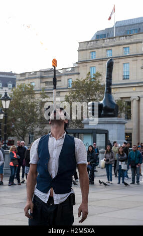 Londres, Royaume-Uni. 30 septembre 2016. Un artiste de rue effectue dans un contexte de la nouvelle œuvre d'art en bronze appelée "Vraiment bien" par l'artiste David Shrigley sur l'affichage à Trafalgar Square. Le public peut profiter de voir une main géante d'un mètre de long, sept de façon disproportionnée le pouce. L'œuvre est destiné à apporter un sentiment de positivité pour le spectateur. Crédit : Stephen Chung / Alamy Live News Banque D'Images