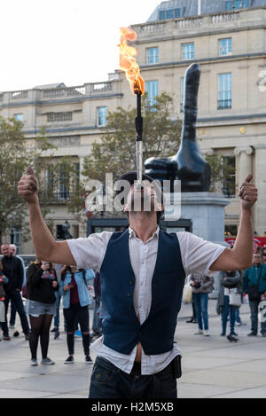 Londres, Royaume-Uni. 30 septembre 2016. Un artiste de rue effectue dans un contexte de la nouvelle œuvre d'art en bronze appelée "Vraiment bien" par l'artiste David Shrigley sur l'affichage à Trafalgar Square. Le public peut profiter de voir une main géante d'un mètre de long, sept de façon disproportionnée le pouce. L'œuvre est destiné à apporter un sentiment de positivité pour le spectateur. Crédit : Stephen Chung / Alamy Live News Banque D'Images