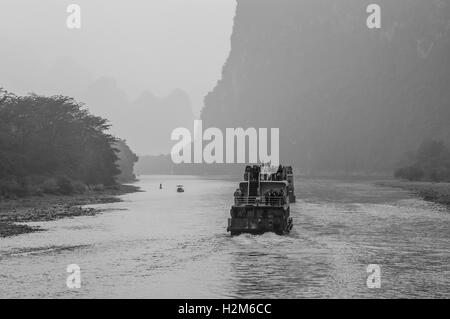 Un des bateaux de tourisme rempli de touristes voyages la magnifique route panoramique le long de la rivière Li de Guilin à Yangshou Banque D'Images