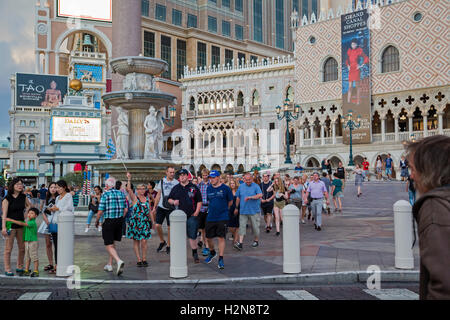 Las Vegas, Nevada - Un guide pour les ondes un drapeau son groupe à suivre en face de l'hôtel et casino de Venise. Banque D'Images