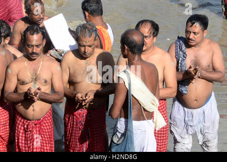 Kolkata, Inde. Sep 30, 2016. Un prêtre hindou aide les dévots d'offrir un hommage à ses ancêtres qu'il prend part au 'rituel' Mahalaya Tarpan pendant les prières sur les rives de la rivière Ganga. Mahalaya hindou Bengali observer le dernier jour de Pitri ( Forenight Paksha de pères) en rendant hommage aux ancêtres(Pitri) dans les ghats du Gange. Les Bengalis à travers le monde souligneront le festival qui représente la victoire du bien sur le mal et la célébration de l'énergie féminine du 08 au 11 octobre qui est tombé en Devi Paksha. Credit : Saikat Paul/Pacific Press/Alamy Live News Banque D'Images