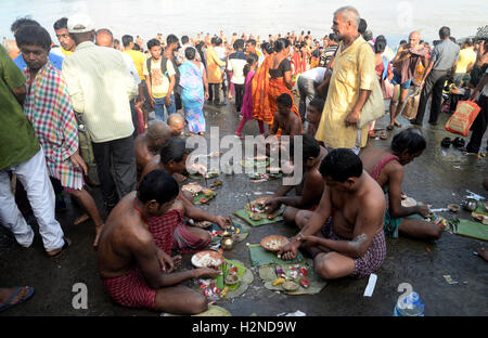 Kolkata, Inde. Sep 30, 2016. Un prêtre hindou aide un fervent hommage à offrir à ses ancêtres qu'il prend part au 'rituel' Mahalaya Tarpan pendant les prières sur les rives de la rivière Ganga. Mahalaya hindou Bengali observer le dernier jour de Pitri ( Forenight Paksha de pères) en rendant hommage aux ancêtres(Pitri) dans les ghats du Gange. Les Bengalis à travers le monde souligneront le festival qui représente la victoire du bien sur le mal et la célébration de l'énergie féminine du 08 au 11 octobre qui est tombé en Devi Paksha. Credit : Saikat Paul/Pacific Press/Alamy Live News Banque D'Images