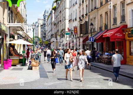 Les gens marchent dans la rue Montorgueil rue sur journée ensoleillée à Paris. Des cafés, des petits commerces et de l'architecture des bâtiments de style français sont en Banque D'Images